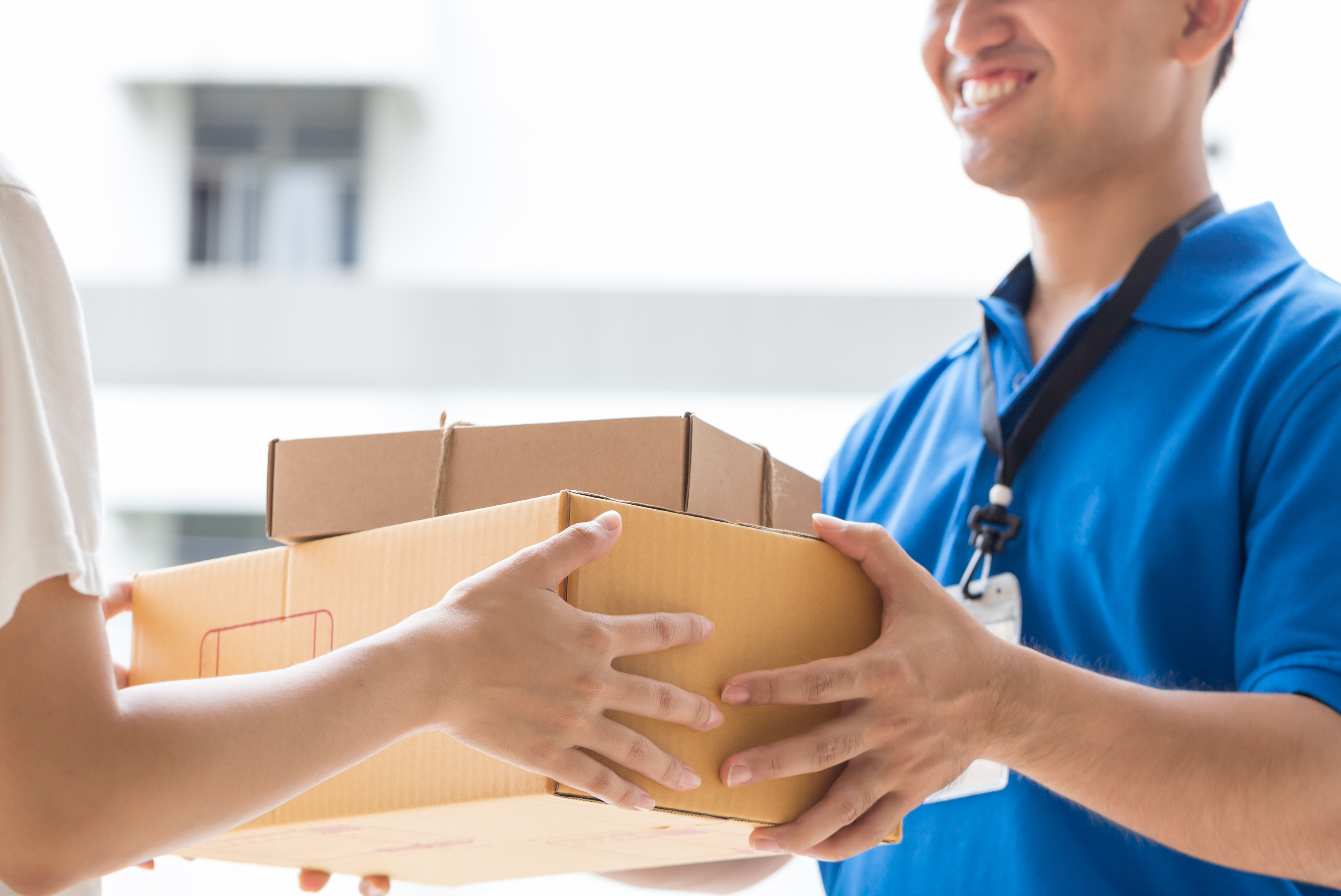 Woman Accepting A Delivery Of Boxes From Deliveryman